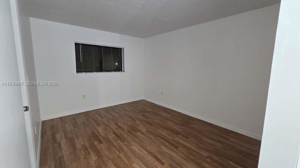 301 Palm Way, Unit 205 Pembroke Pines, FL 33025 - Photo 16 of 23 a view of an empty room with wooden floor and a window