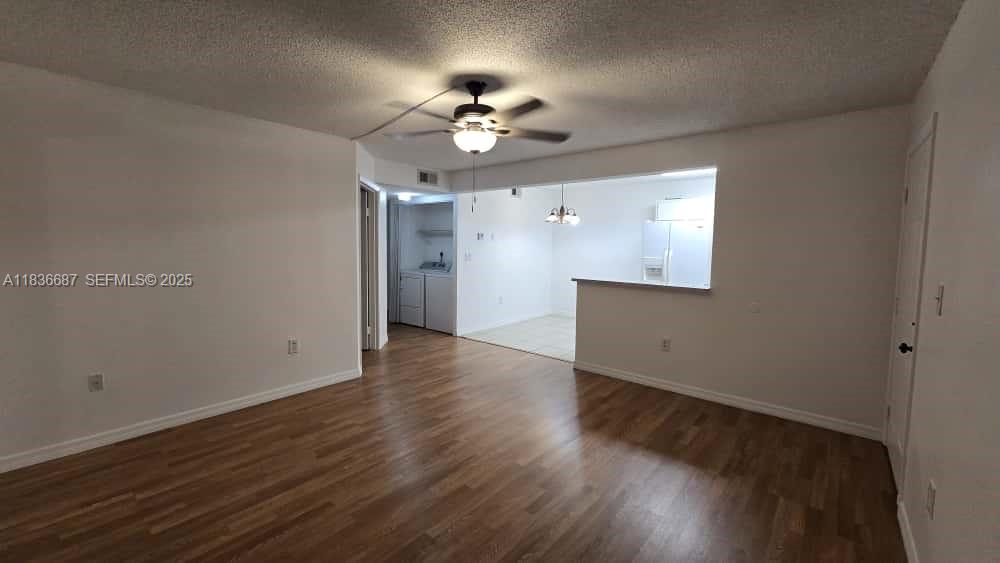 301 Palm Way, Unit 205 Pembroke Pines, FL 33025 - Photo 2 of 23 an empty room with wooden floor chandelier fan and entryway