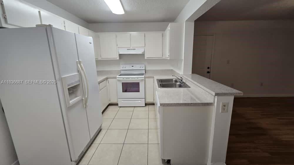 301 Palm Way, Unit 205 Pembroke Pines, FL 33025 - Photo 8 of 23 a kitchen with a refrigerator sink and cabinets