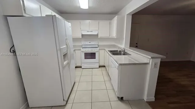 a white refrigerator freezer sitting inside of a kitchen