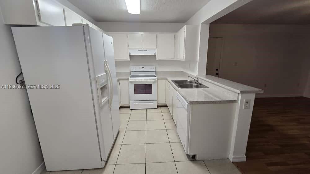 301 Palm Way, Unit 205 Pembroke Pines, FL 33025 - Photo 10 of 23 a white refrigerator freezer sitting inside of a kitchen