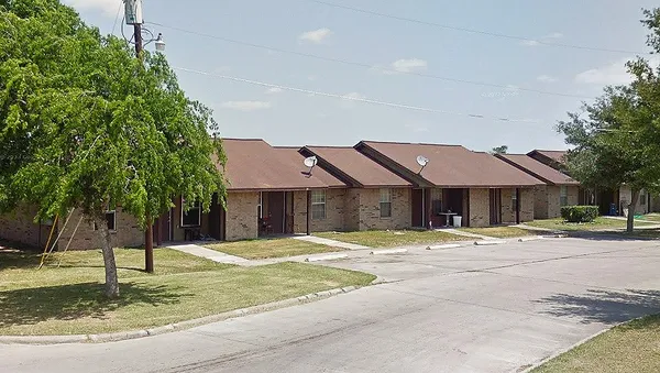 a yellow house with trees in front of it