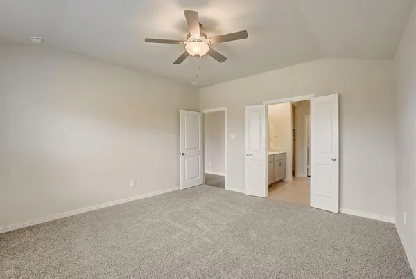 an empty room with closet and a ceiling fan