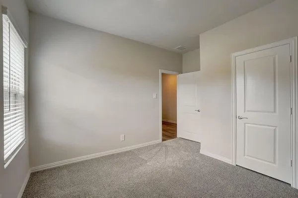 an empty room with windows and closet