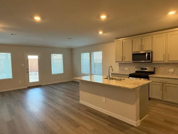 a view of a kitchen with wooden floor and electronic appliances