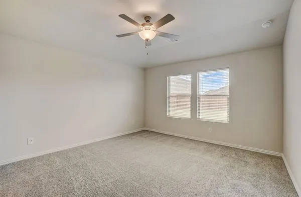 an empty room with a window and a ceiling fan