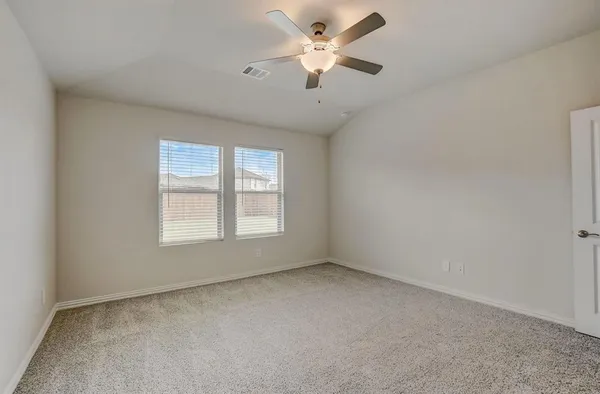 an empty room with a window and a ceiling fan