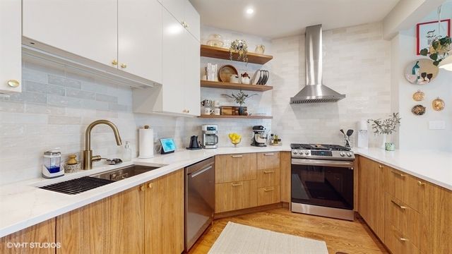 a kitchen with stainless steel appliances granite countertop a sink and a stove