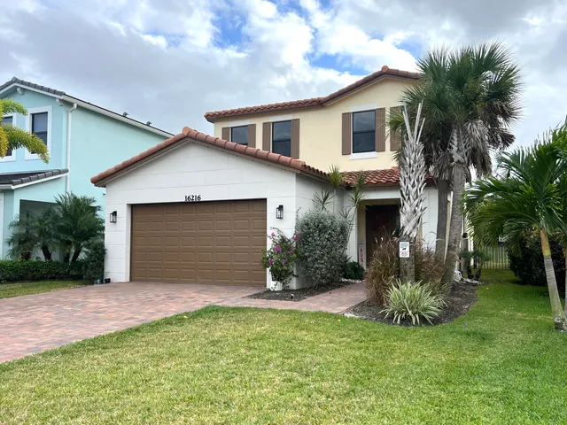 a front view of a house with a yard and garage