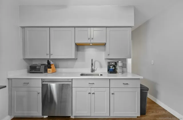 a kitchen with white cabinets and sink
