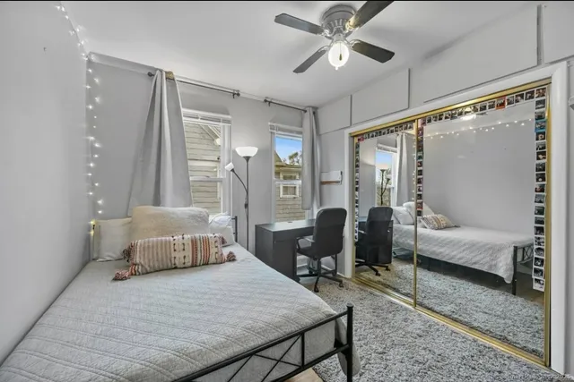 a bedroom with a bed couch and a large window