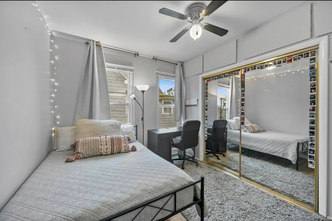 115 Harborview Avenue, Unit 1 Bridgeport, CT 06605 - Photo 8 of 11 a bedroom with a bed couch and a large window