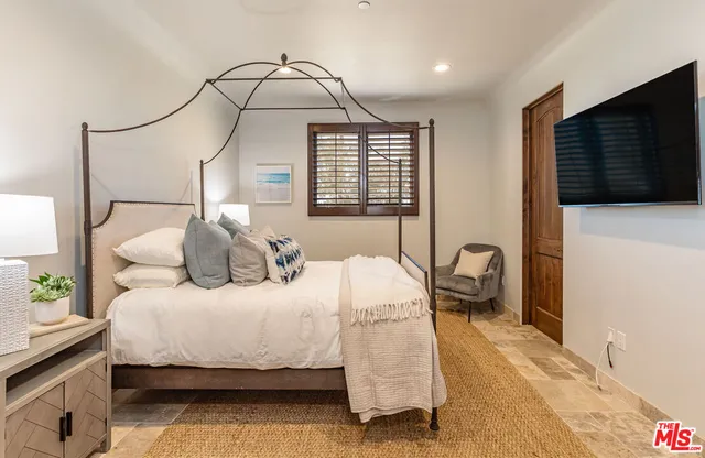 a bedroom with furniture a fireplace and a flat screen tv