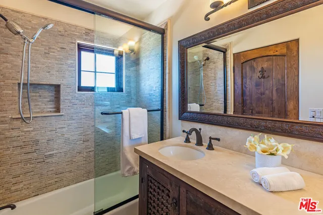 a bedroom with bed a flat tv screen and a night stand