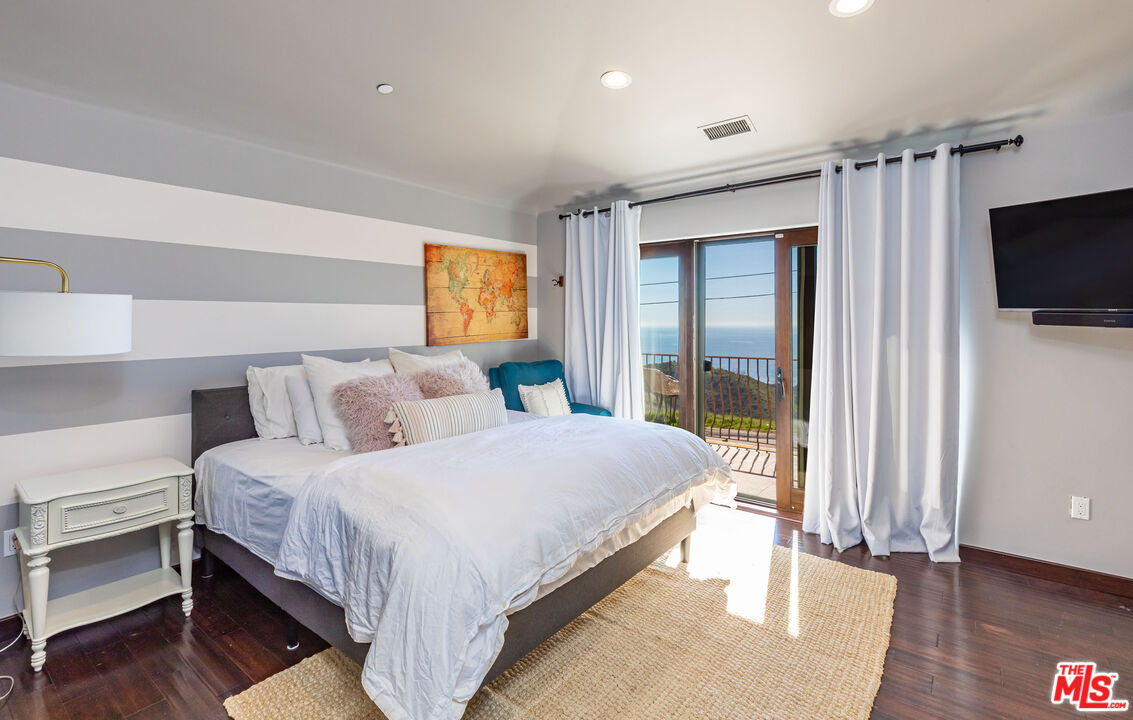 4800 Latigo Canyon Road Malibu, CA 90265 - Photo 37 of 56 a bedroom with bed a flat tv screen and a night stand