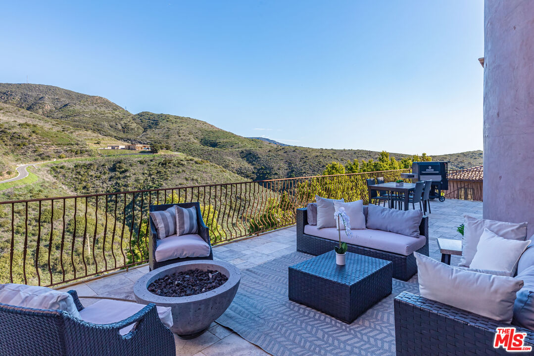 4800 Latigo Canyon Road Malibu, CA 90265 - Photo 38 of 56 a view of a patio with couches chairs and a potted plant