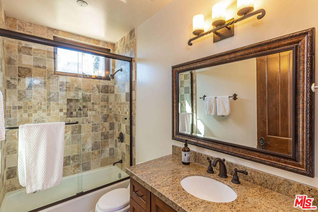4800 Latigo Canyon Road Malibu, CA 90265 - Photo 49 of 56 a bathroom with a granite countertop sink toilet a mirror and shower