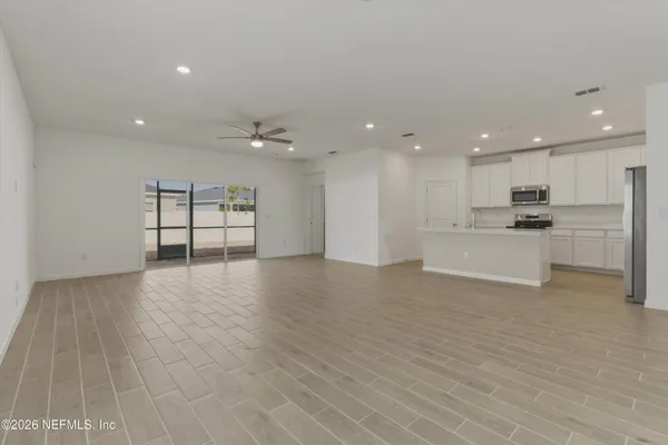 an empty room with a ceiling fan and a window