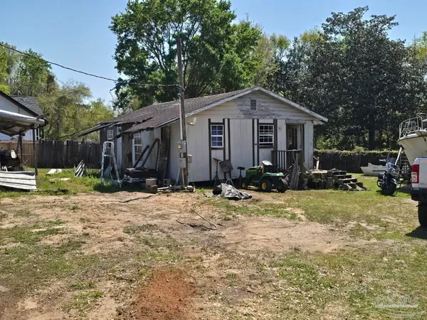 a view of a house with a yard and large tree