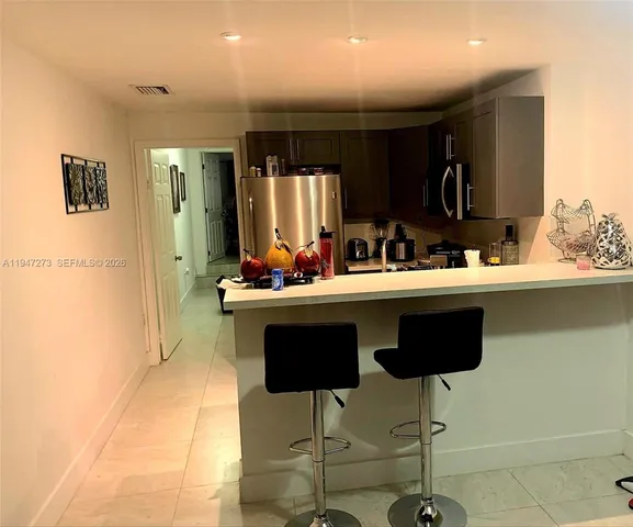a kitchen with a dining table chairs sink and cabinets