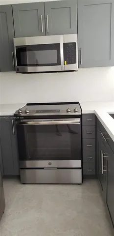a kitchen with granite countertop a stove and a microwave