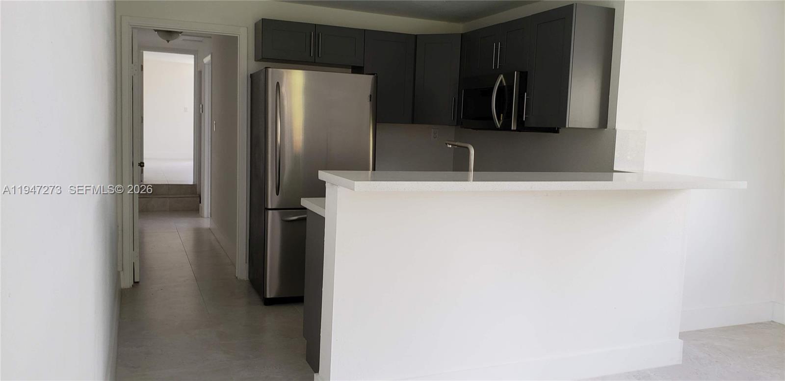 9285 Southwest 37th Street Miami, FL 33165 - Photo 5 of 17 a bathroom with a sink and a refrigerator