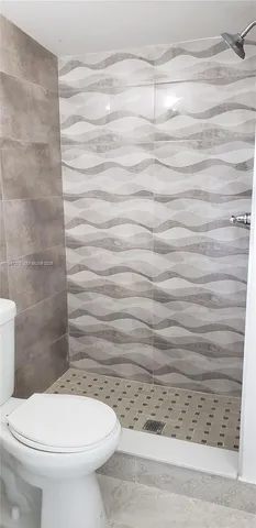 a bathroom with a toilet and a shower