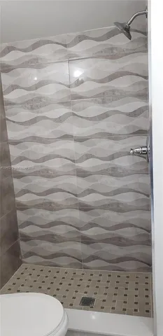 a bathroom with a toilet and a shower