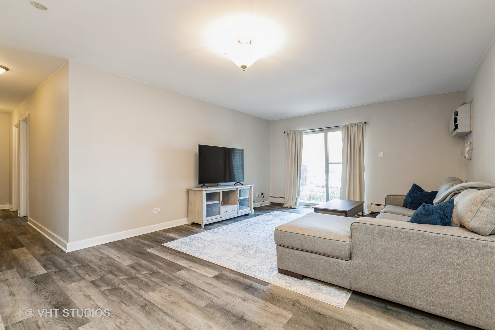 516 North Wilke Road, Unit 106 Palatine, IL 60074 - Photo 7 of 20 a living room with furniture and a flat screen tv
