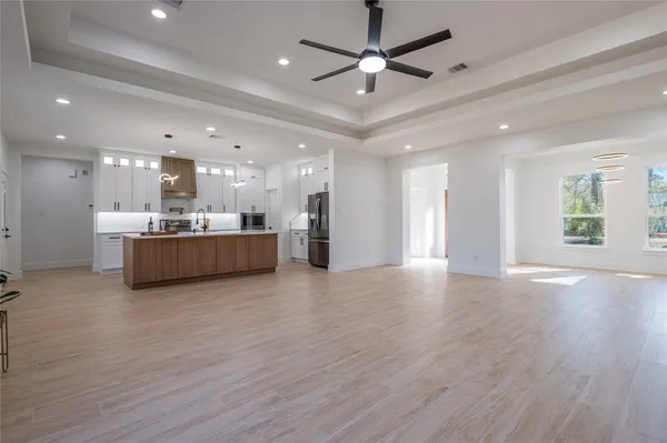 a view of a big room with wooden floors and kitchen