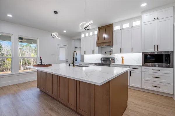 a kitchen with sink stove and refrigerator