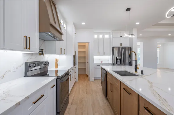 a large kitchen with stainless steel appliances lots of counter space and a sink