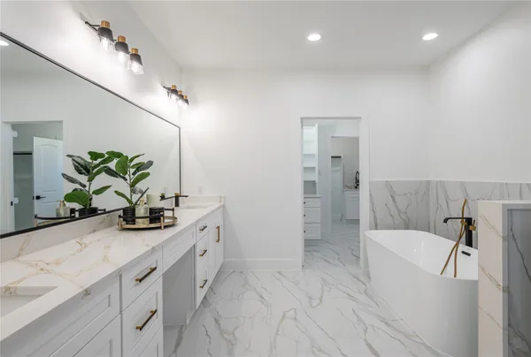 a bathroom with a double vanity sink a mirror and a bathtub