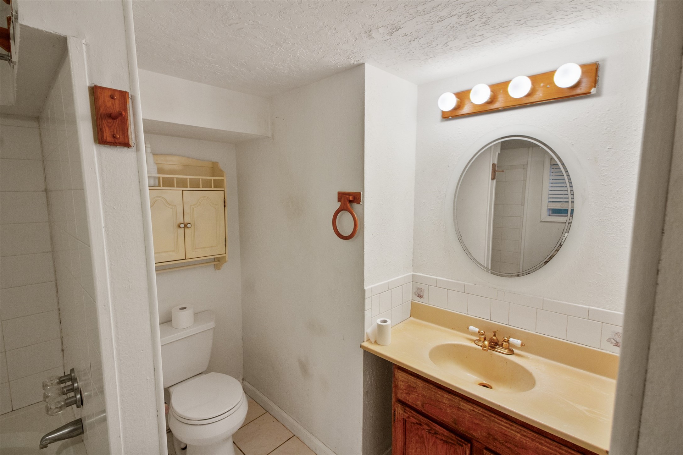 317 West Lewis Street Conroe, TX 77301 - Photo 24 of 30 a bathroom with a toilet sink vanity and mirror