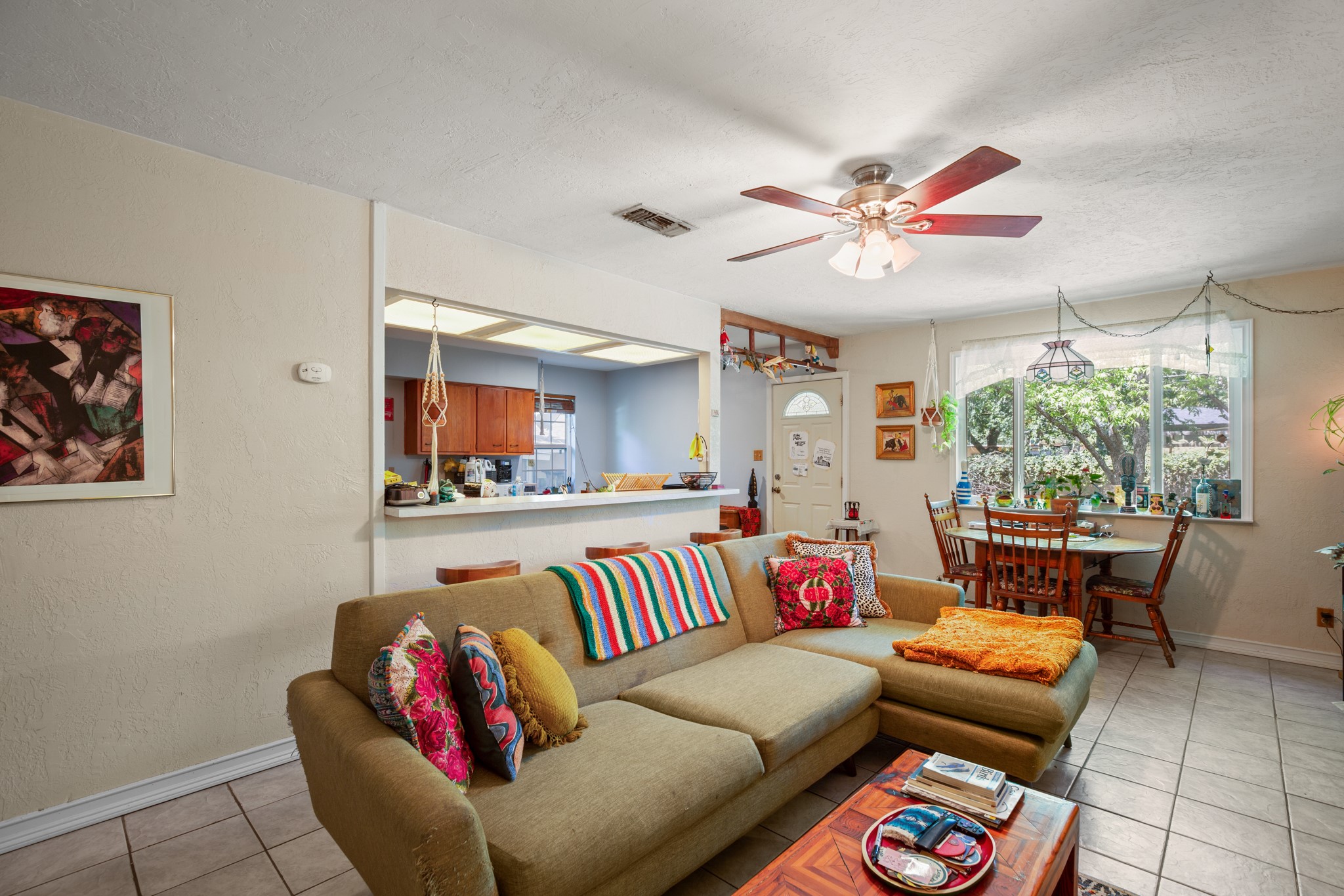 4606 South 2nd Street Austin, TX 78745 - Photo 15 of 24 Living area featuring light tile patterned flooring, visible vents, a ceiling fan, and baseboards