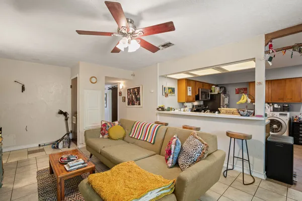 a living room with furniture and a dining table with kitchen view
