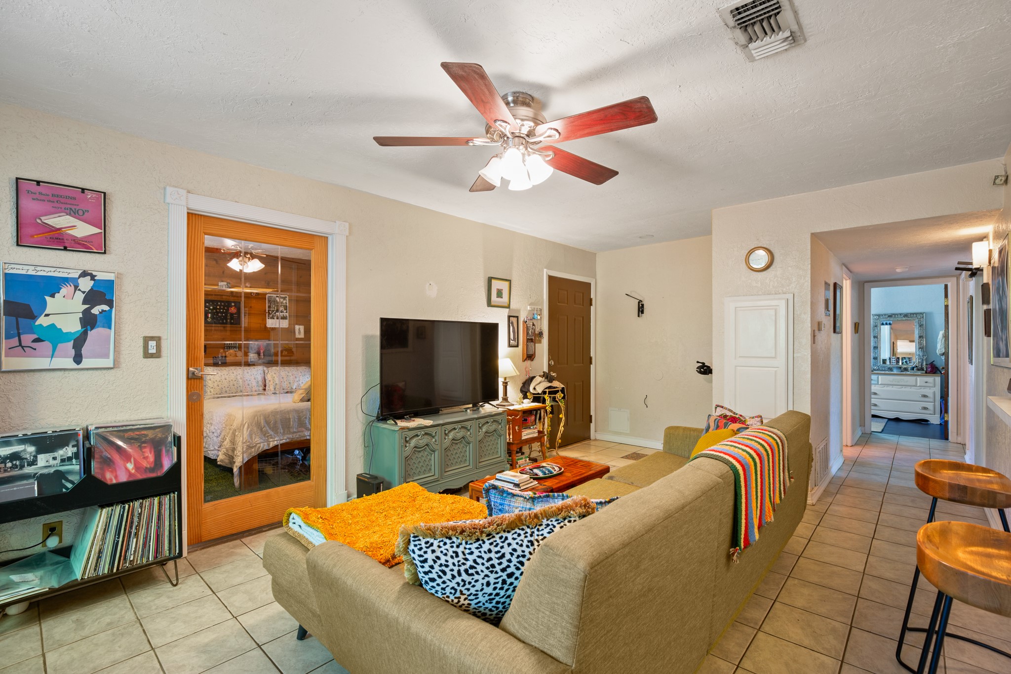 4606 South 2nd Street Austin, TX 78745 - Photo 17 of 24 Living room with light tile patterned flooring, visible vents, and a ceiling fan
