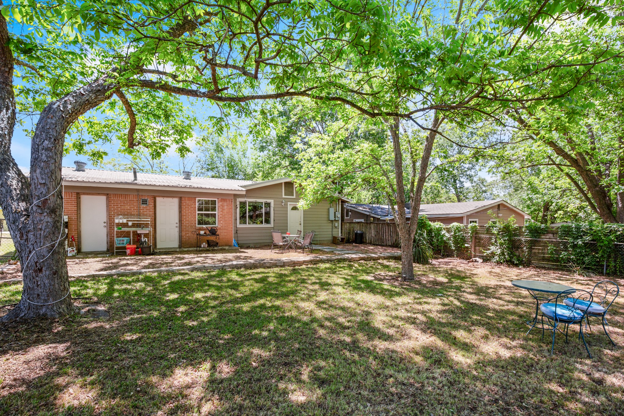 4606 South 2nd Street Austin, TX 78745 - Photo 4 of 24 Back of house featuring brick siding, fence, a patio area, and a lawn