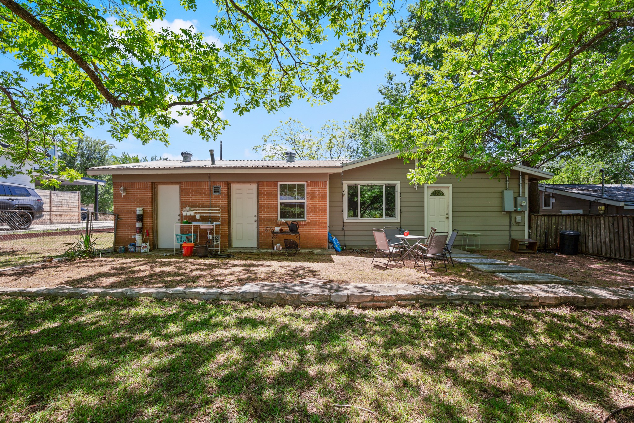 4606 South 2nd Street Austin, TX 78745 - Photo 5 of 24 Rear view of property featuring brick siding, fence, a yard, and a patio area
