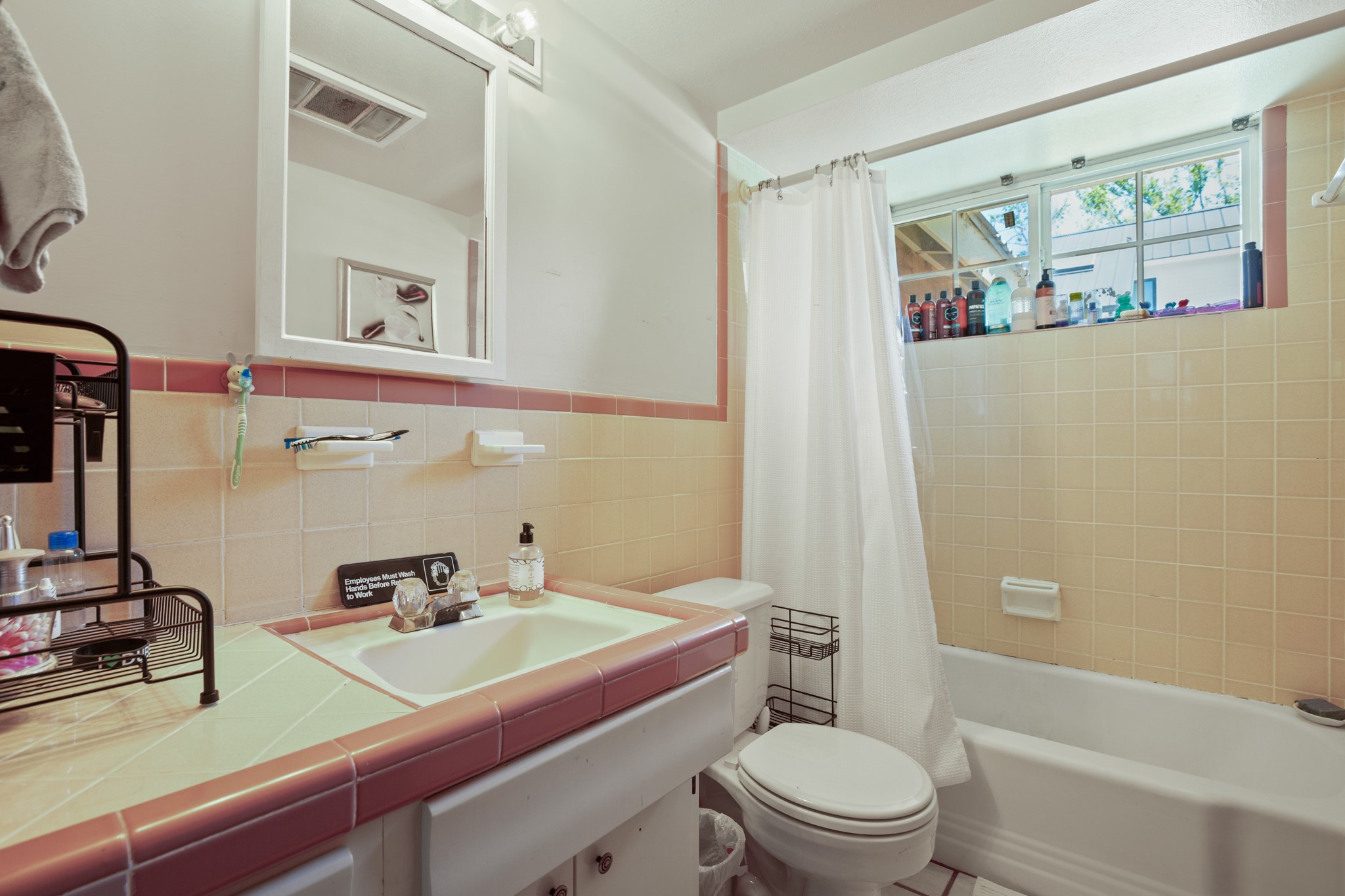 4606 South 2nd Street Austin, TX 78745 - Photo 7 of 24 Full bath featuring tile walls, shower / bath combination with curtain, toilet, visible vents, and wainscoting