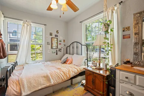 a bedroom with a bed and a large window with the outer view