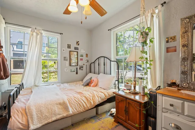 a bedroom with a bed and a large window with the outer view