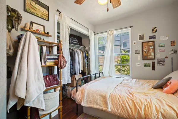 a bedroom with a bed a book shelf and a window