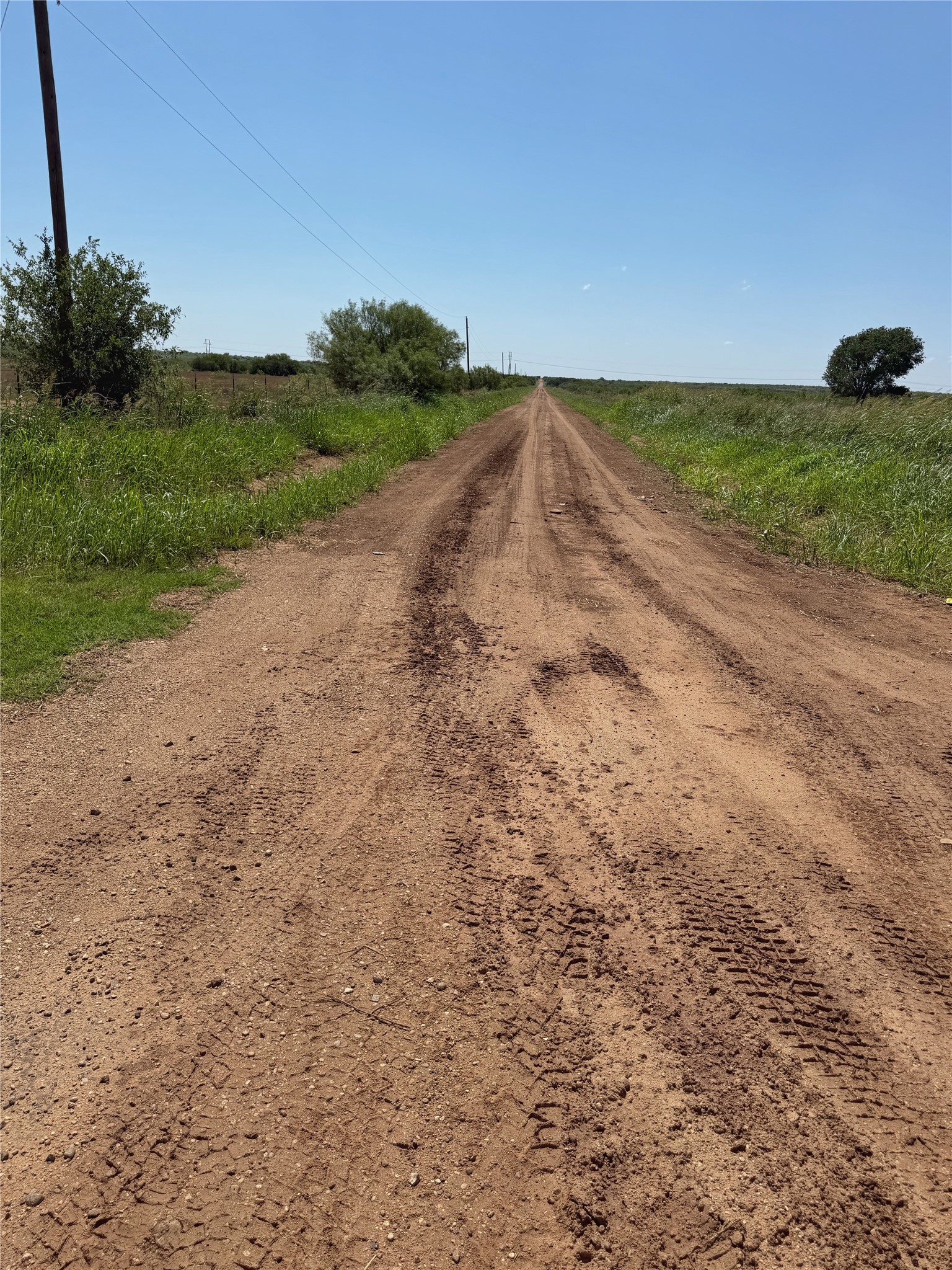 Nka Buckle L Road Childress, TX 79201 - Photo 9 of 12 Wide, level ranch road running alongside secure perimeter wire fencing and open land.
