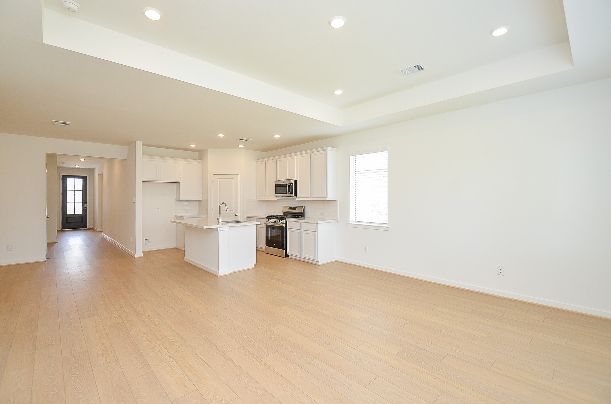 9727 Rialto Hts Drive Cypress, TX 77433 - Photo 19 of 37 This modern kitchen features sleek white cabinetry, stainless steel appliances, and a large island with a built-in sink. The space is bright and airy offering a clean, contemporary look.