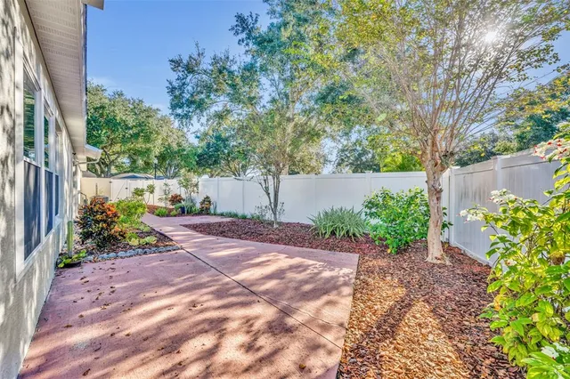 a view of swimming pool with lawn chairs and plants