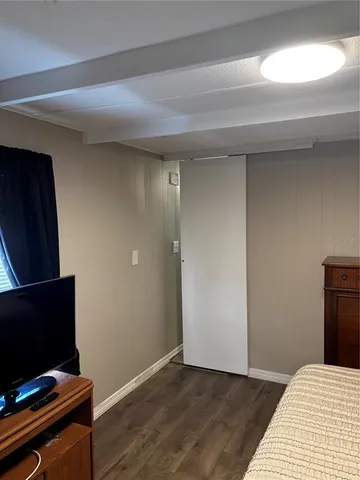 a view of a livingroom with wooden floor and a flat screen tv