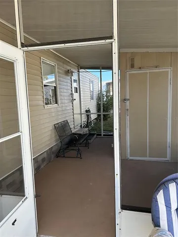 a view of a hallway with a chair and dining table view