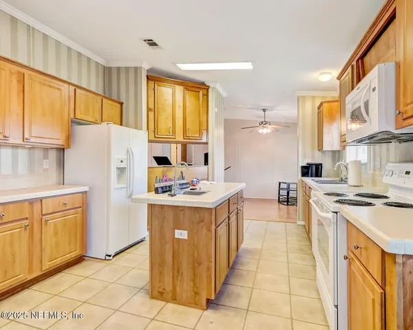 a kitchen with a sink a counter top space stainless steel appliances cabinets and a window