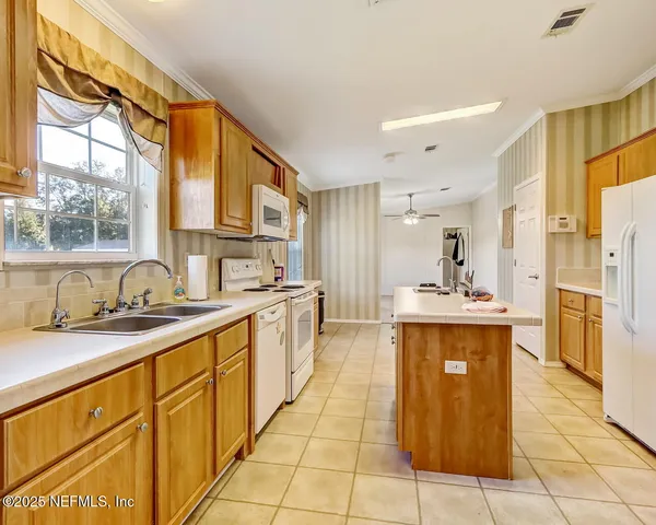 a large kitchen with stainless steel appliances granite countertop a sink and cabinets
